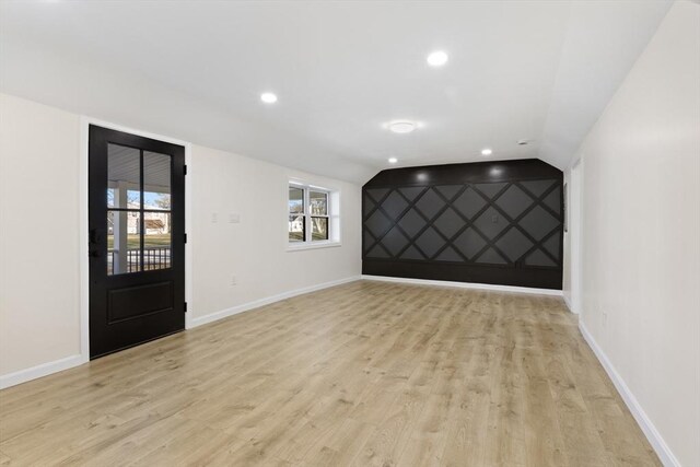 unfurnished room featuring an accent wall, recessed lighting, light wood-style floors, and baseboards
