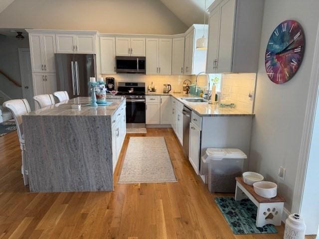 1 Karas Way, Plymouth, MA 02360 - kitchen with appliances with stainless steel finishes, a sink, vaulted ceiling, a kitchen island, and white cabinetry