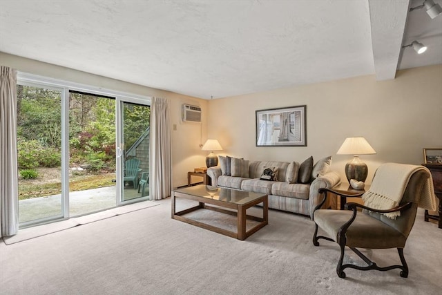 carpeted living room featuring a wall mounted air conditioner and a textured ceiling