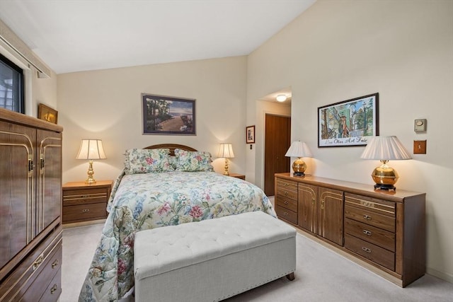 bedroom with lofted ceiling and light colored carpet