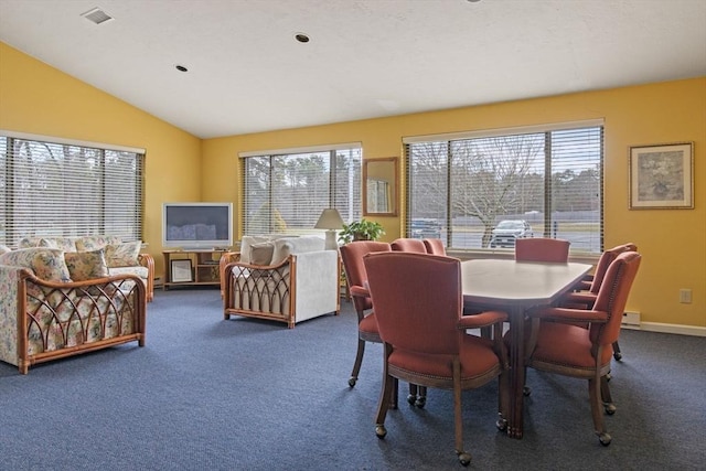 carpeted dining space featuring healthy amount of natural light and lofted ceiling