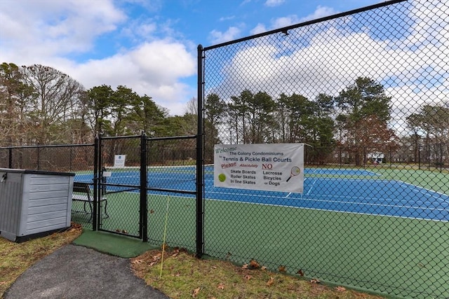 view of tennis court featuring a gate and fence