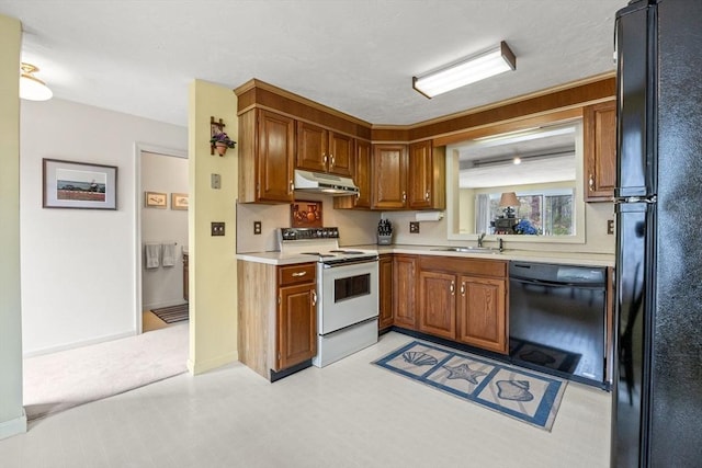 kitchen with black appliances, under cabinet range hood, a sink, light countertops, and brown cabinets