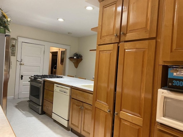16 Knox St, Worcester, MA 01603 - kitchen featuring appliances with stainless steel finishes, light countertops, brown cabinets, a sink, and recessed lighting