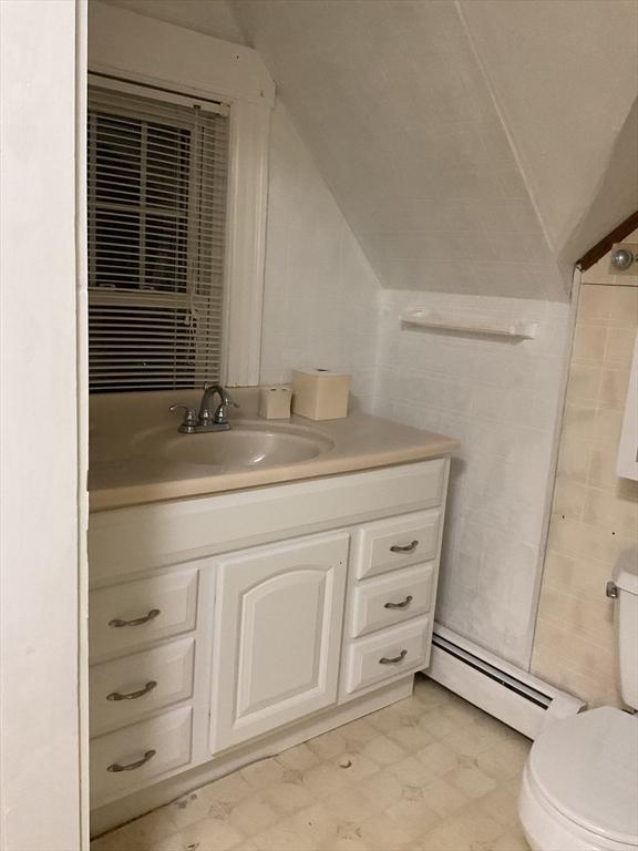 16 Knox St, Worcester, MA 01603 - bathroom with a baseboard radiator, vanity, toilet, lofted ceiling, and tile patterned floors