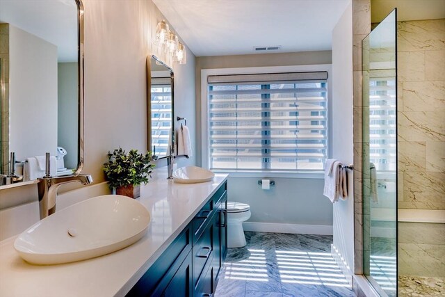 full bathroom with tiled shower, visible vents, a sink, and marble finish floor