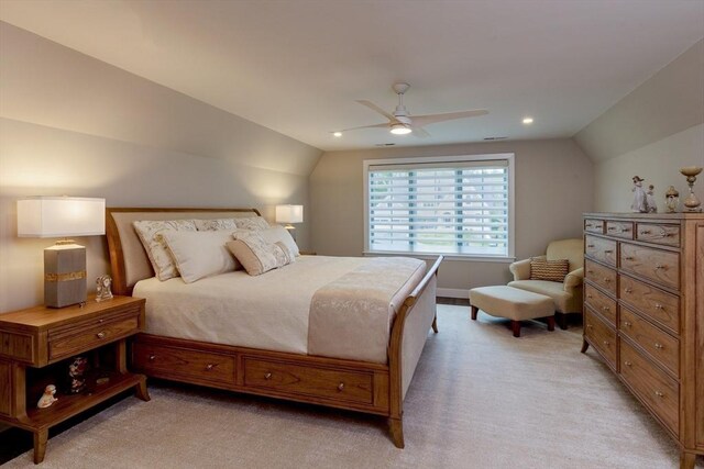 bedroom with a ceiling fan, vaulted ceiling, and light carpet