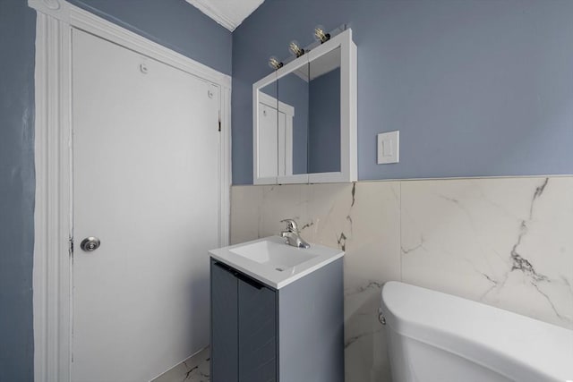half bath with marble finish floor, vanity, and toilet