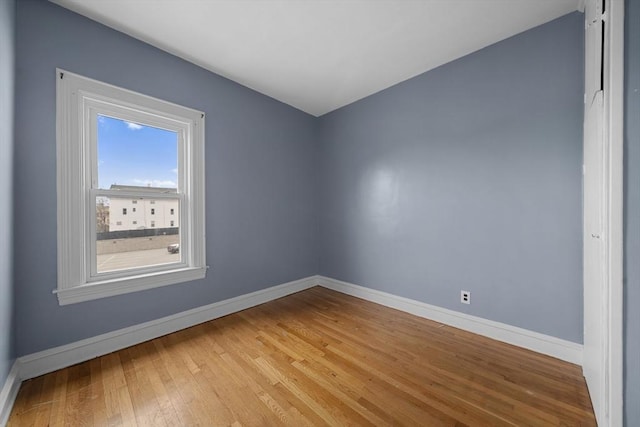 unfurnished room featuring baseboards and light wood-type flooring