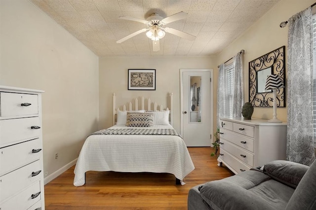 bedroom featuring light wood finished floors, ceiling fan, and baseboards