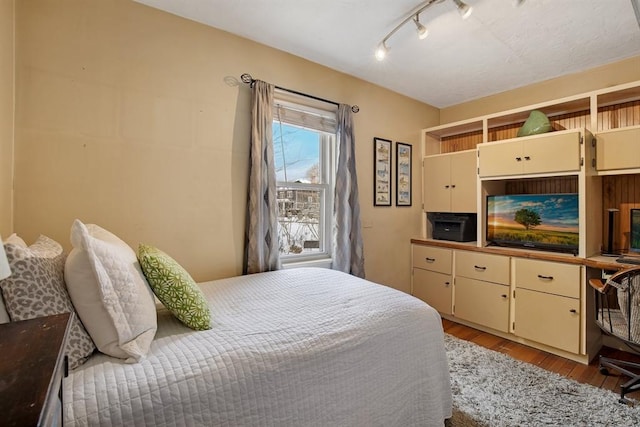 bedroom with light wood-style flooring and track lighting