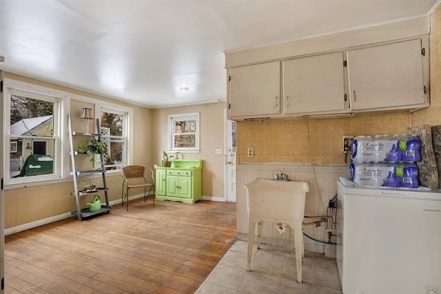 laundry room featuring washer / dryer, light wood-type flooring, and baseboards