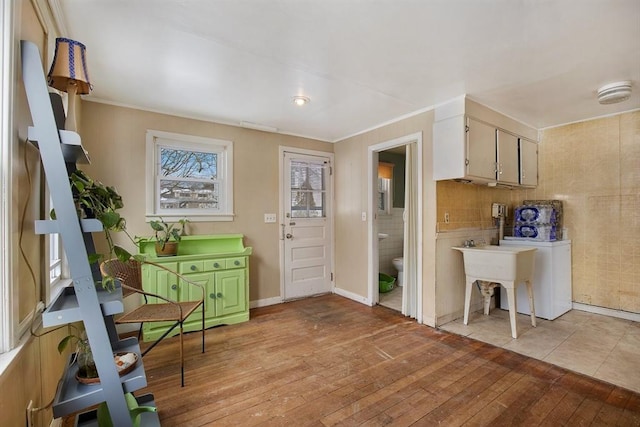 kitchen with baseboards, ornamental molding, and light wood-style floors