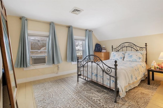 bedroom featuring baseboards, visible vents, lofted ceiling, cooling unit, and light wood-style floors