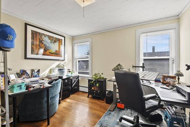 office area with baseboard heating, crown molding, and wood finished floors