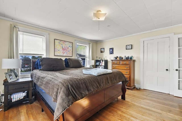 bedroom with crown molding and light wood-style floors