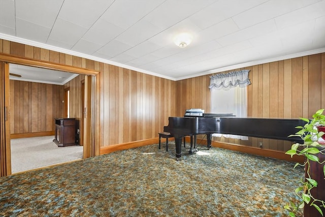 living area featuring crown molding, carpet, wood walls, and baseboards