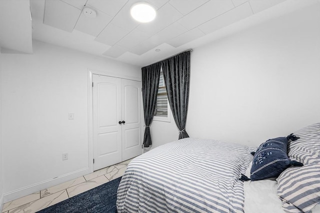 bedroom with light marble finish flooring and a closet