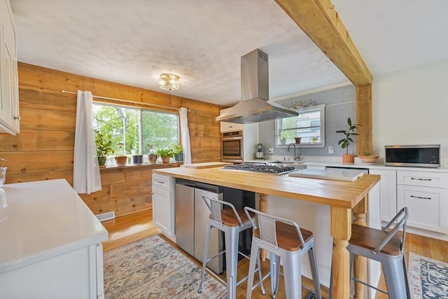 62 Greenbrier Dr, New Bedford, MA 02745 - kitchen featuring butcher block countertops, island exhaust hood, healthy amount of natural light, light wood-style floors, and wood walls