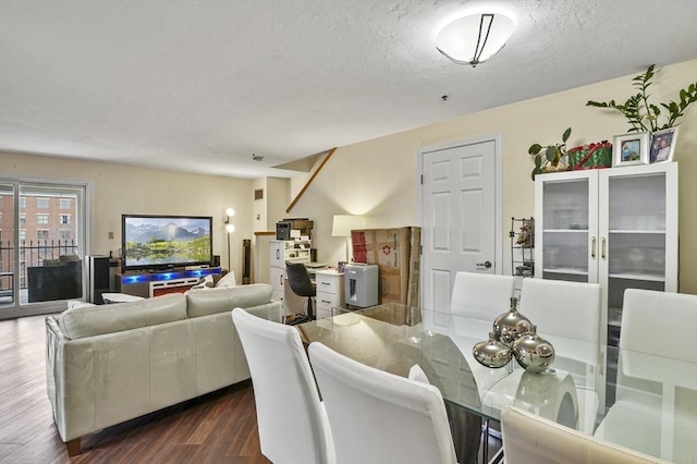 dining area with dark wood-type flooring and a textured ceiling