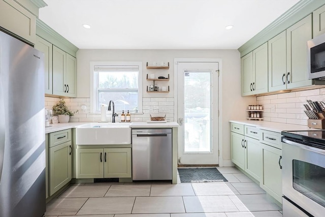 kitchen with green cabinets, stainless steel appliances, and light countertops