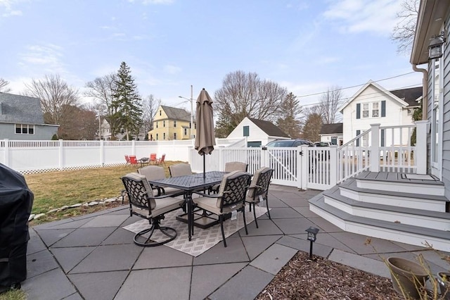 view of patio with outdoor dining area, a fenced backyard, and a residential view