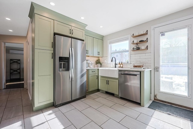 kitchen featuring open shelves, appliances with stainless steel finishes, light countertops, and green cabinetry