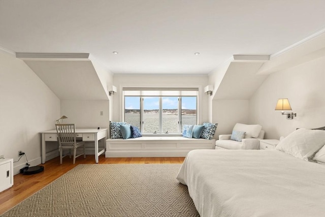 bedroom featuring baseboards, wood finished floors, and crown molding