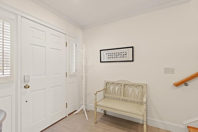 entryway with light wood-type flooring, baseboards, and crown molding