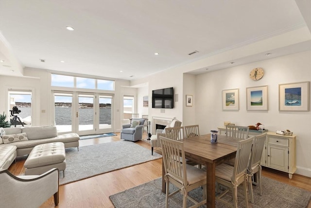 dining area featuring visible vents, baseboards, recessed lighting, a fireplace, and wood finished floors