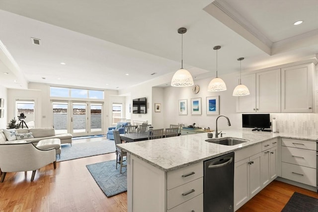 kitchen with a sink, visible vents, a peninsula, and open floor plan