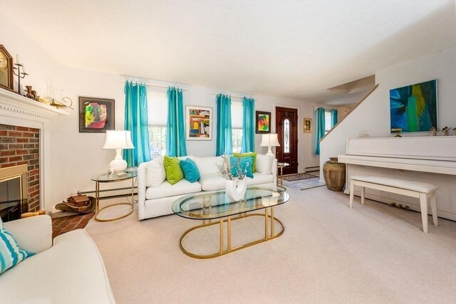 carpeted living area with baseboard heating, stairs, and a brick fireplace