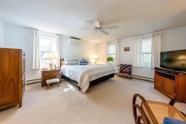 bedroom with ceiling fan, a wall mounted AC, baseboard heating, and light carpet