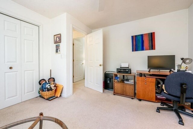 office area featuring baseboards and light carpet