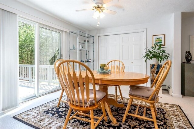 dining area with ceiling fan and light colored carpet