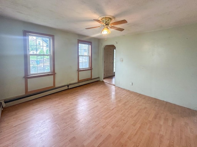 233 Grove St, Woonsocket, RI 02895 - unfurnished room featuring ceiling fan, wood finished floors, arched walkways, and a baseboard radiator
