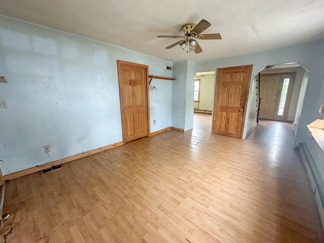 233 Grove St, Woonsocket, RI 02895 - spare room featuring arched walkways, a ceiling fan, light wood-style flooring, baseboards, and a baseboard radiator