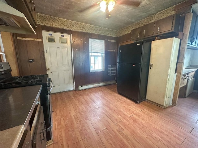 233 Grove St, Woonsocket, RI 02895 - kitchen with freestanding refrigerator, a baseboard heating unit, range with gas cooktop, a ceiling fan, and under cabinet range hood