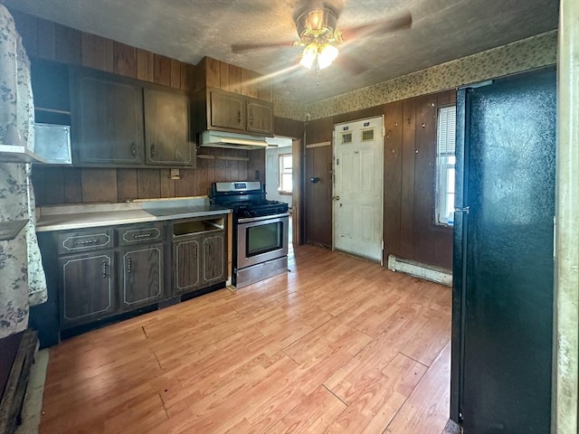 233 Grove St, Woonsocket, RI 02895 - kitchen with stainless steel range with gas cooktop, baseboard heating, under cabinet range hood, light wood-style flooring, and ceiling fan