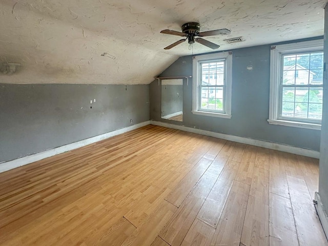 233 Grove St, Woonsocket, RI 02895 - additional living space with vaulted ceiling, a ceiling fan, light wood finished floors, baseboards, and a textured ceiling