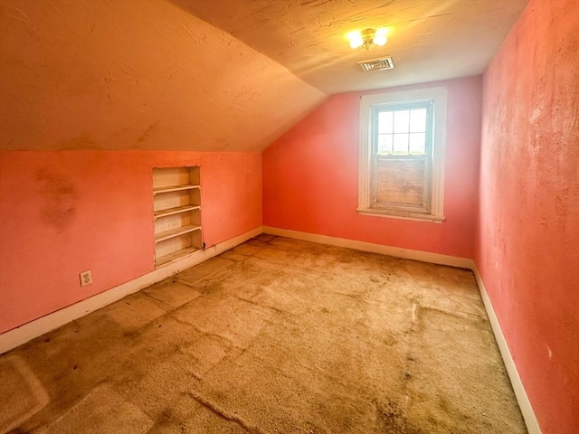233 Grove St, Woonsocket, RI 02895 - bonus room featuring built in shelves, carpet floors, baseboards, lofted ceiling, and a textured ceiling