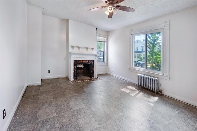 72 Hall St, Springfield, MA 01108 - unfurnished living room with radiator heating unit, a ceiling fan, a textured ceiling, and a premium fireplace