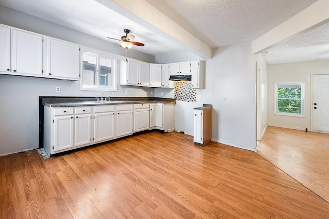 72 Hall St, Springfield, MA 01108 - kitchen featuring under cabinet range hood, light wood-style flooring, a ceiling fan, white cabinetry, and beamed ceiling