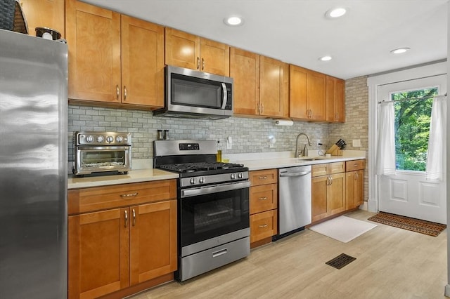 171 Boyce St, Auburn, MA 01501 - kitchen featuring stainless steel appliances, light countertops, light wood-type flooring, decorative backsplash, and recessed lighting