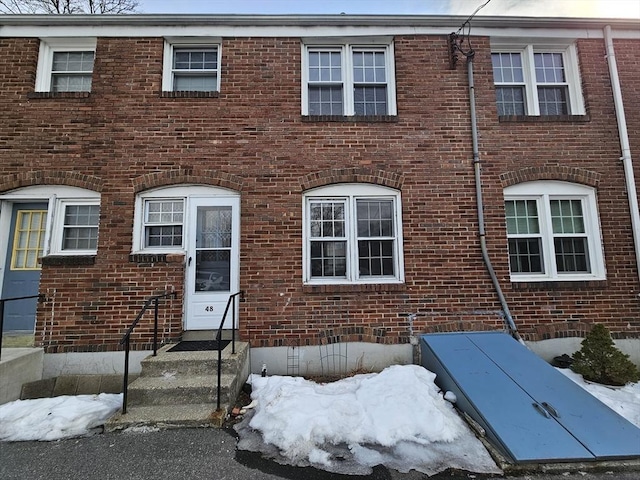 view of front facade with entry steps, crawl space, and brick siding