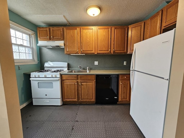 kitchen featuring brown cabinets, a sink, a textured ceiling, white appliances, and under cabinet range hood