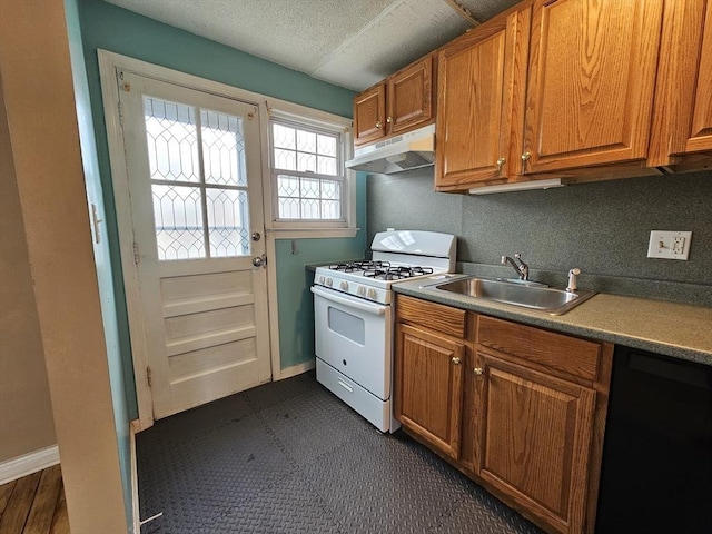 kitchen featuring black dishwasher, white range with gas stovetop, brown cabinets, under cabinet range hood, and a sink