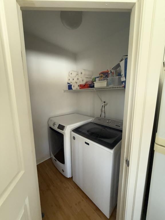 laundry area featuring washer and dryer, laundry area, and light wood finished floors