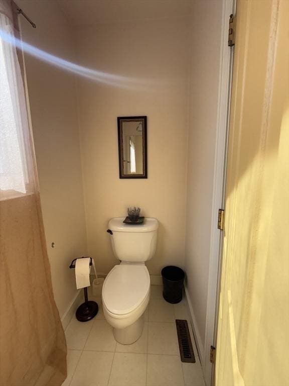 bathroom with baseboards, visible vents, toilet, and tile patterned floors