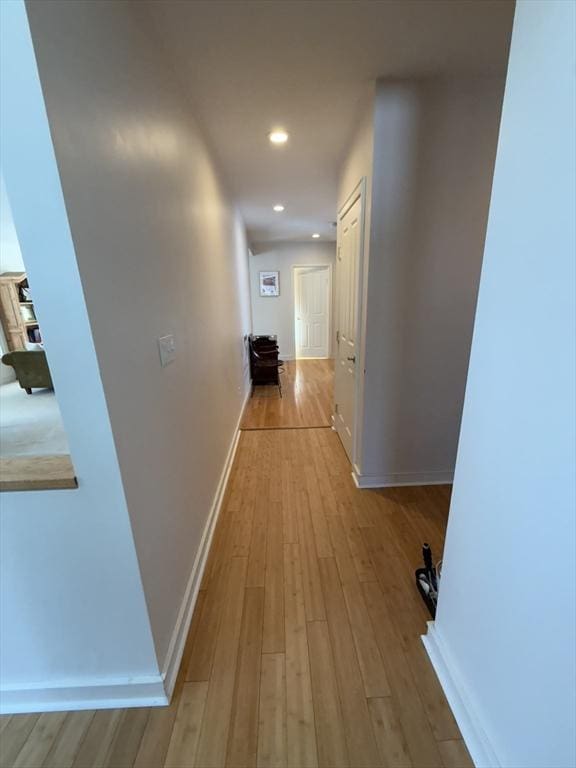 corridor featuring recessed lighting, light wood-type flooring, and baseboards